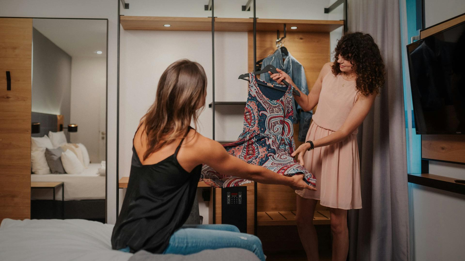 Zwei Mädels im Hotelzimmer beim Entscheiden der Outfits