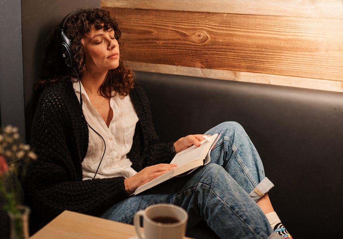 Frau hört Musik und trinkt Kaffee